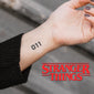 A person's forearm with a temporary tattoo of the number '011'