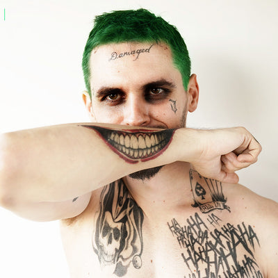 joker arm smile tattoo