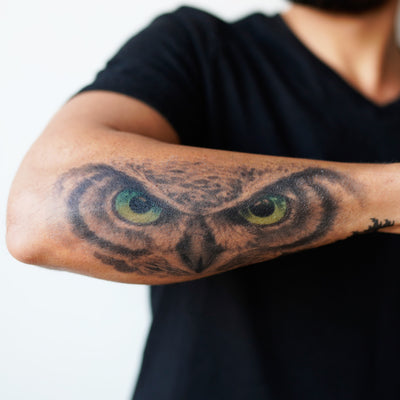 owl eyes forearm tattoo